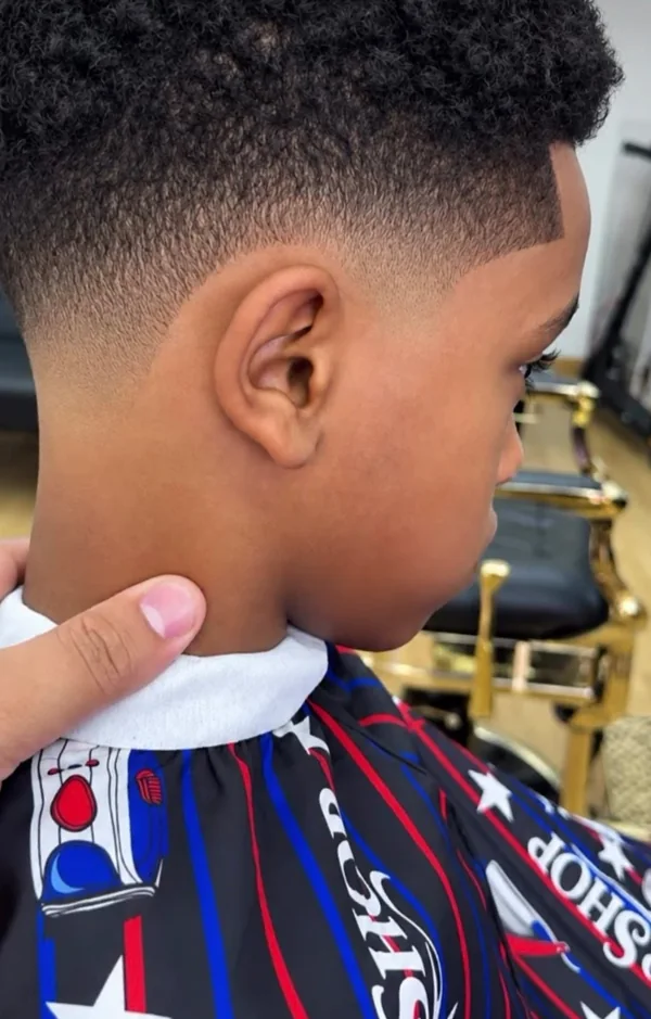 Seitlicher Fade mit klarer Haarlinie und natürlichen Locken